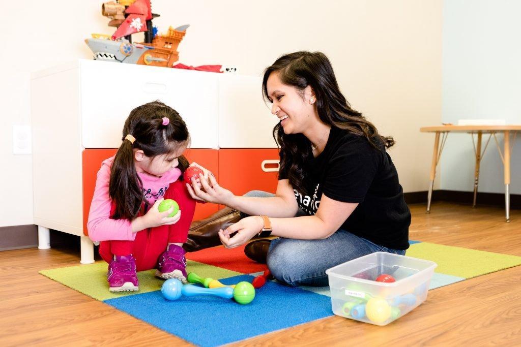 A Registered Behavior Technician works 1:1 with a child during an ABA therapy session at Action Behavior Centers