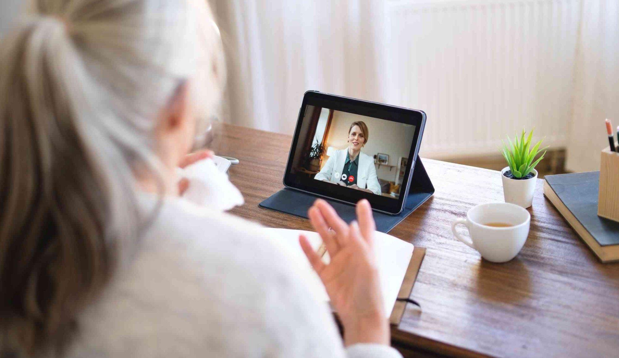 A clinician conducts a telehealth session via tablet. Hi Rasmus serves providers across 60 countries, with AI that converts natural speech into professional clinical narratives and translates content across languages for family communication. | Photo: stock