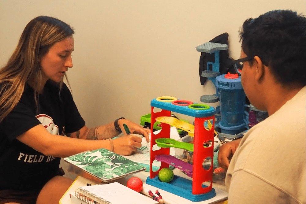 A behavior analyst works one-on-one with a client during an ABA therapy session