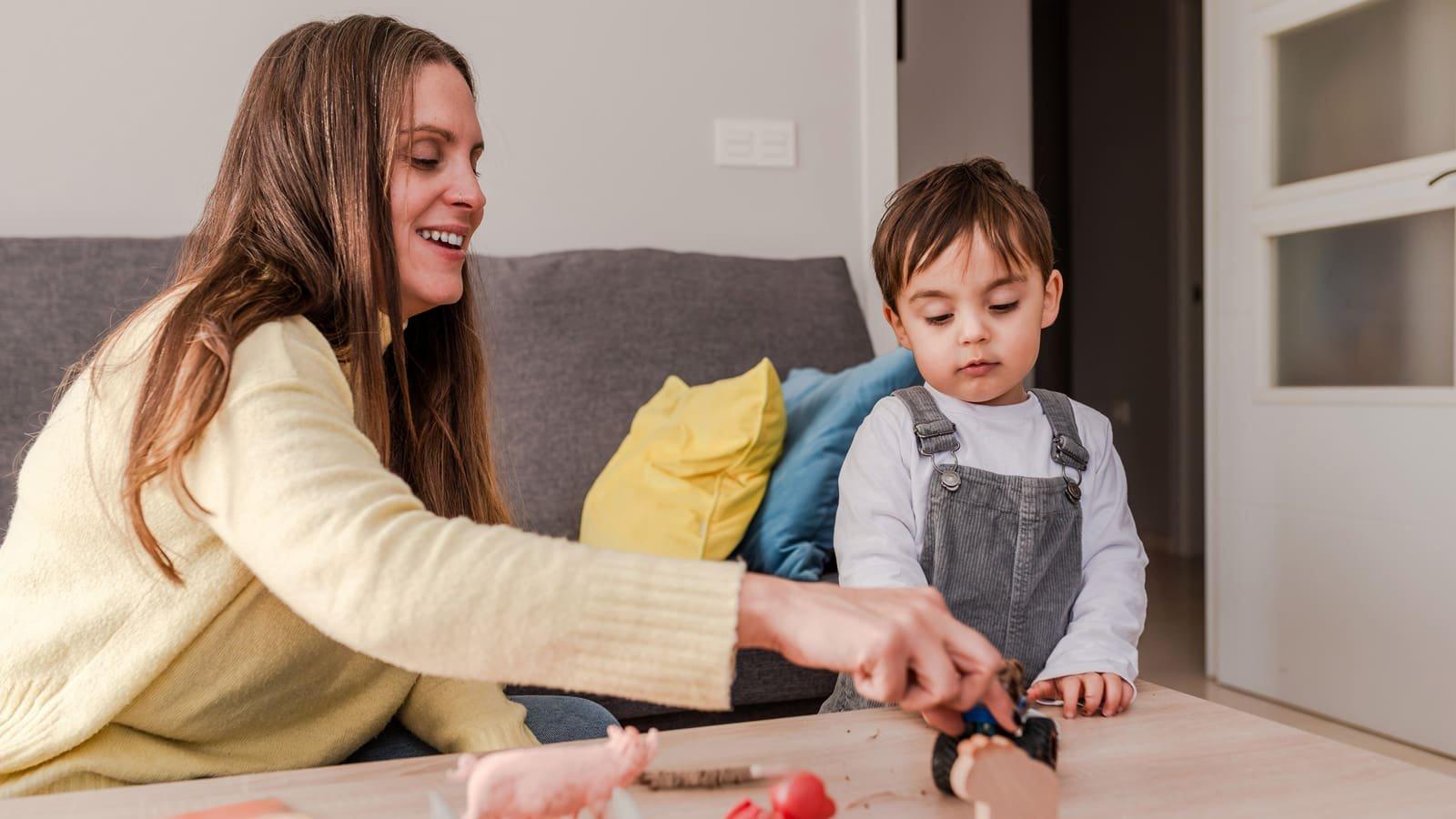 A parent works alongside her child during a therapy session at home