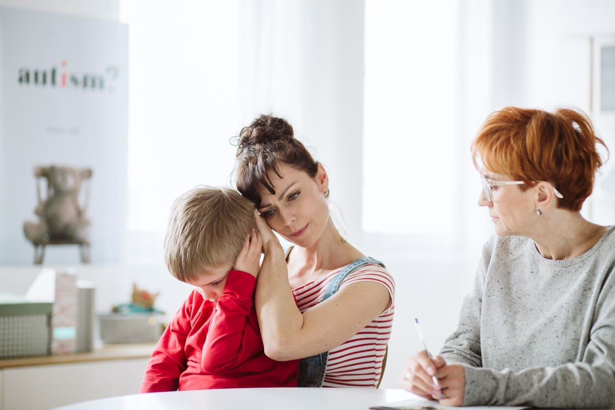 A mother comforts her child during an autism consultation
