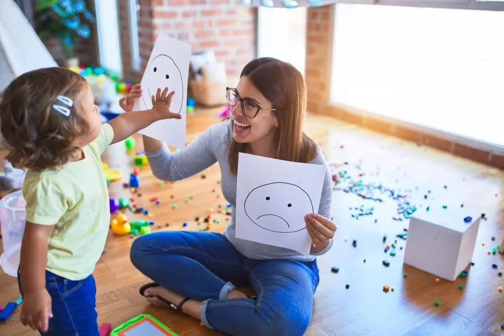 A behavior therapist works one-on-one with a child using educational materials during an ABA session. With RBT turnover exceeding 77% annually, this relationship may last only months.