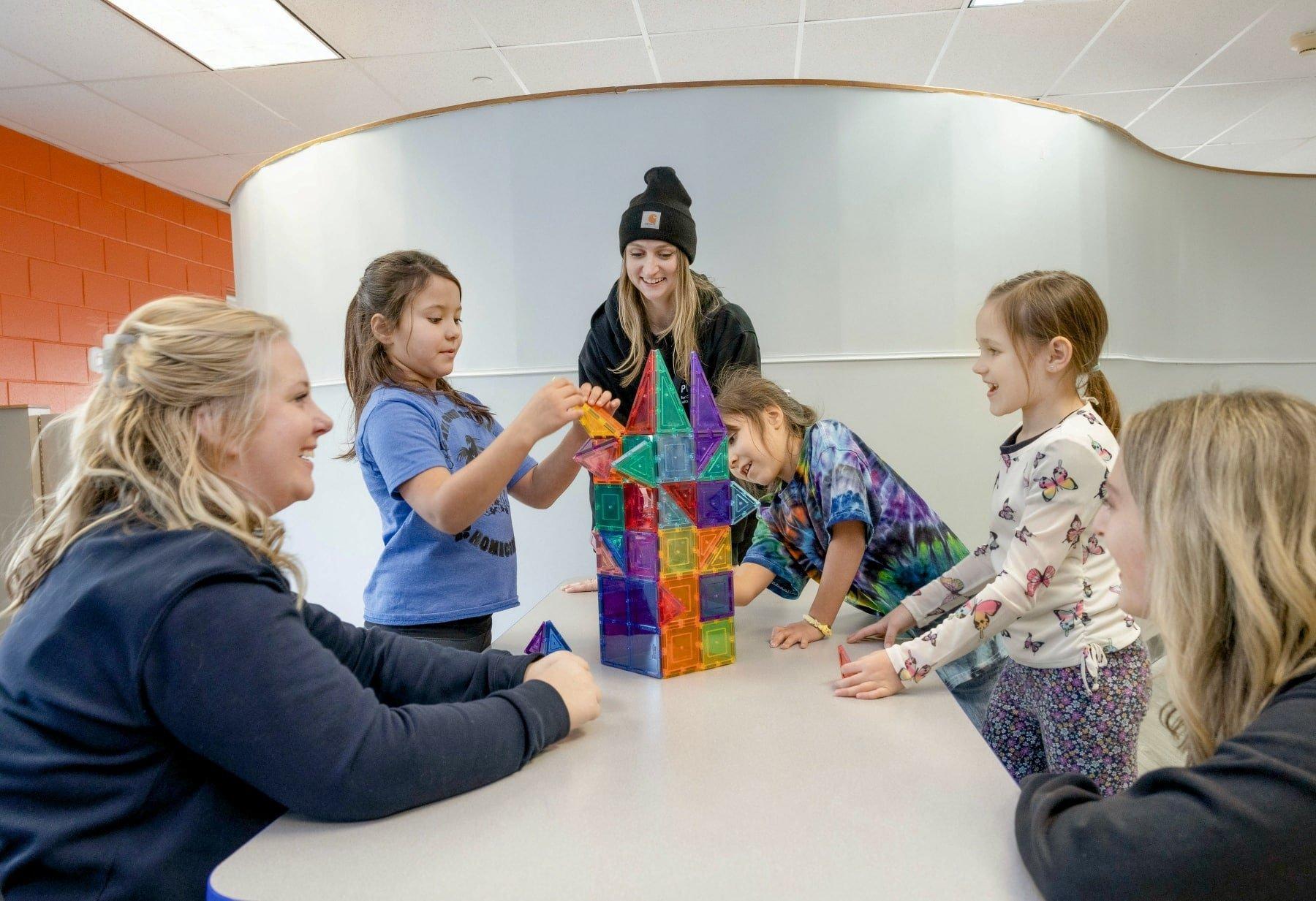 Children and therapists build with magnetic tiles during a group activity at a behavioral therapy center. Action Behavior Centers and Centria together operated roughly 50 facilities statewide.
