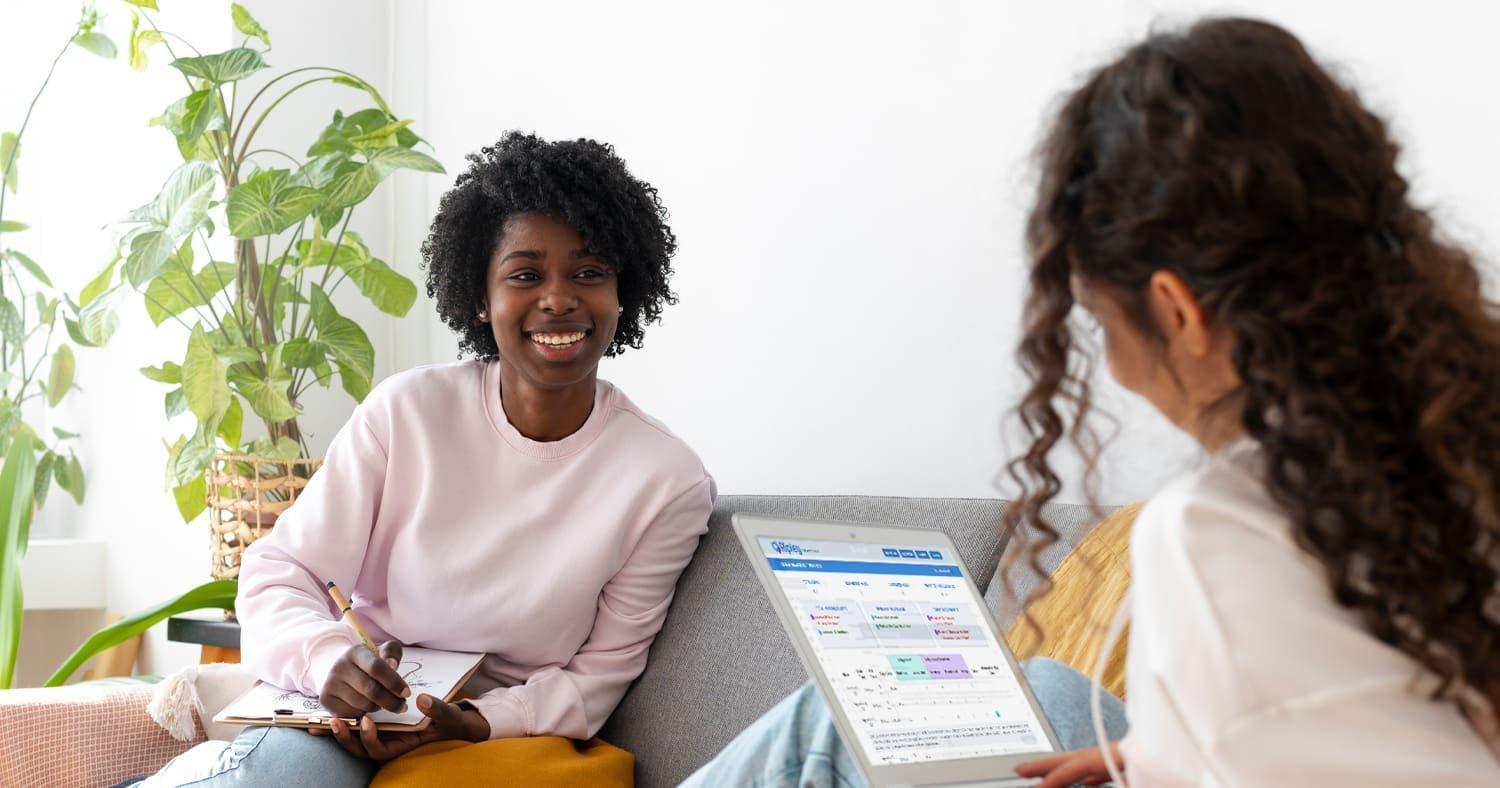 A supervision session between a BCBA and a trainee, with a tablet showing scheduling and data. Supervised fieldwork combines case review, data analysis, and direct observation, all of which the supervisor must document monthly using the BACB-approved verification forms.