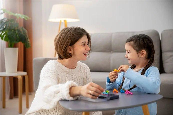 A child works through a play-based activity with an adult at home, the setting STEPS uses to deliver its in-home ABA therapy.